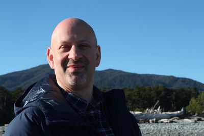 Portrait of smiling man against clear blue sky