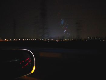 Illuminated city against sky at night