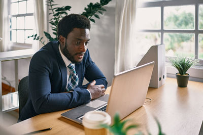 Young man using laptop at table