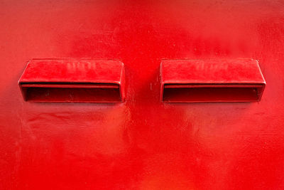 Close-up of mailbox on red wall