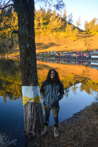 Rear view of woman standing against lake