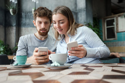 Couple with smartphones in cafe