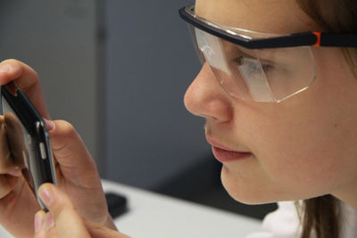 Girl photographing with smart phone in science lab