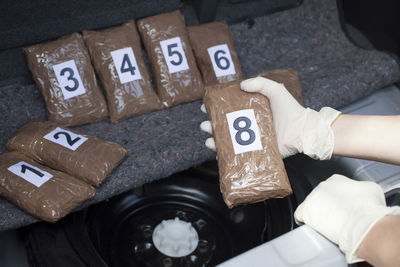 Cropped hand of person holding packet in car