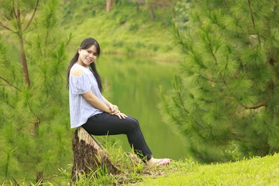 Full length of young woman sitting on land