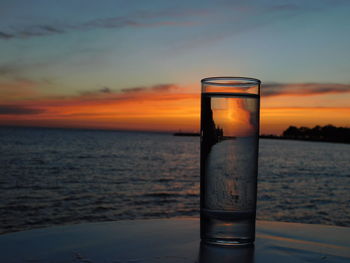 Close-up of water on beach against sky during sunset