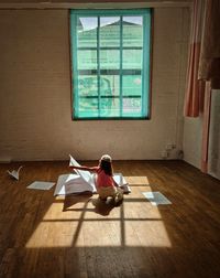 Side view of woman sitting on floor