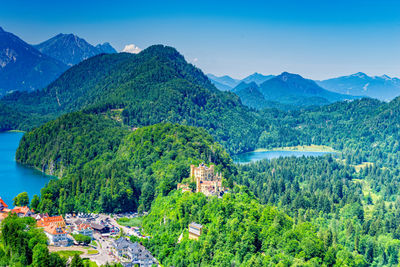 Scenic view of townscape by mountains against sky