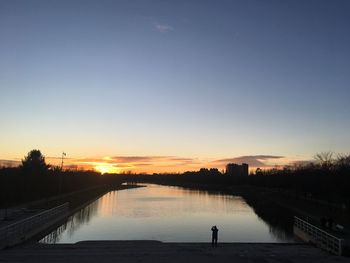 Scenic view of river against clear sky during sunset