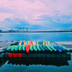 Multi colored boats moored in river against sky