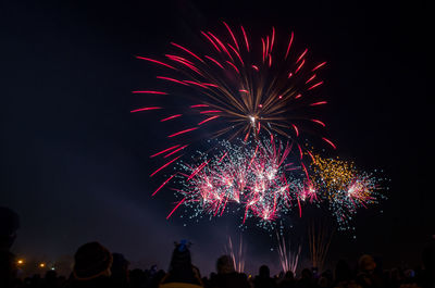 Low angle view of firework display at night