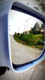 View of road through side-view mirror of car