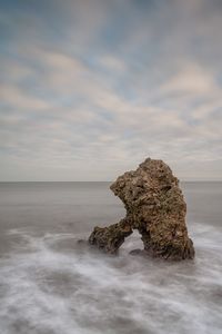 Rocks on sea shore against sky