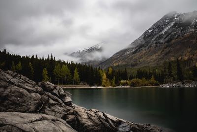 Scenic view of lake and mountains against cloudy sky