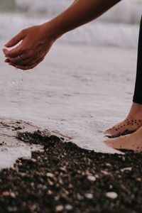 Low section of woman standing at riverbank