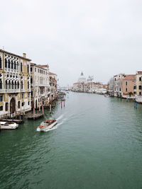 Buildings by river against clear sky