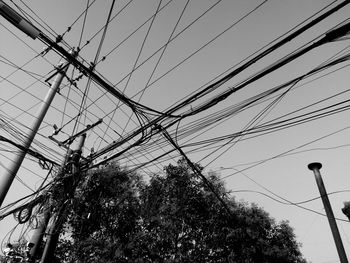 Low angle view of power lines against sky