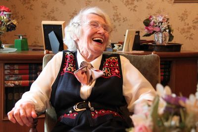 Happy woman sitting on sofa at home