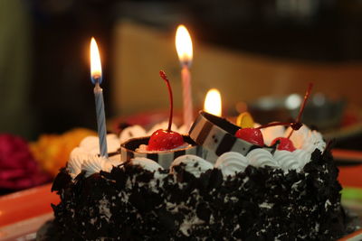 Close-up of burning candles on cake