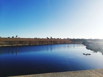 Scenic view of river against clear blue sky