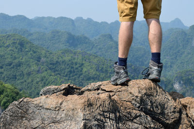 Low section of man standing on mountain