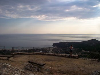 People looking at sea against sky