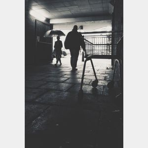 Rear view of silhouette people walking in illuminated building