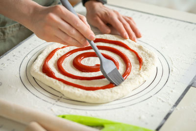 Cropped hand of person preparing cake