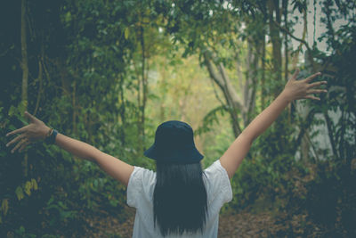 Rear view of woman standing by trees