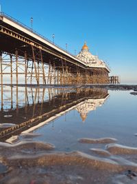 Low tide reflections of the eastbourne pier in the wet san