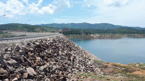 Panoramic view of railroad tracks by mountains against sky