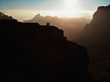 Silhouette rock formations against sky during sunset