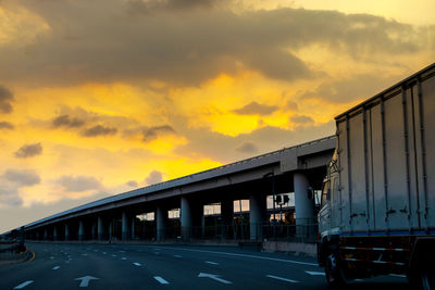 Bridge over road against sky during sunset