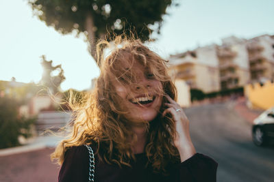 Portrait of smiling young woman in city