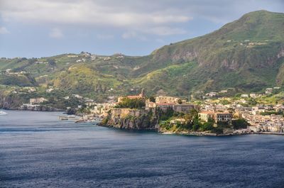 Scenic view of city by sea against sky