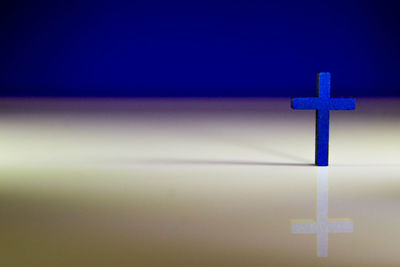 Close-up of cross against blue sky