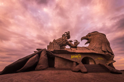 Low angle view of statue against sky at sunset