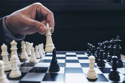 Cropped hand of man playing chess