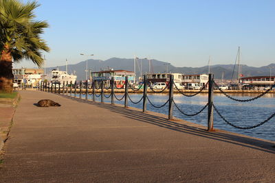 View of boats moored at harbor against clear blue sky