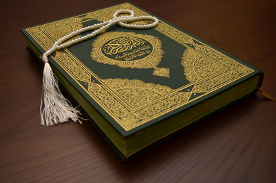 High angle view of koran on wooden table