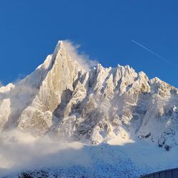 Scenic view of snowcapped mountains against blue sky