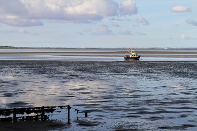 Ship sailing on sea against sky
