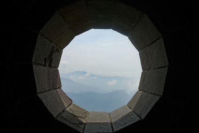 Mountains against sky seen through window