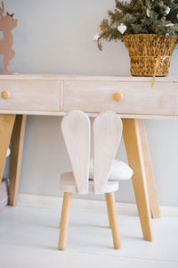 High chair made of wood with bunny ears in the children's room