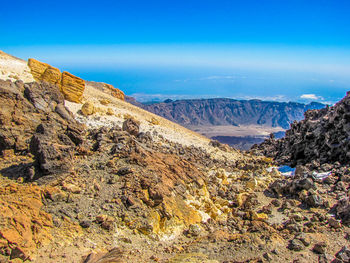 Scenic view of mountains against blue sky