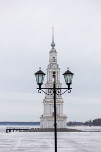 Lighthouse by sea against sky