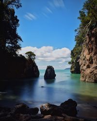 Rocks in sea against sky