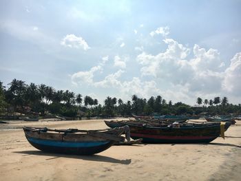 Boats moored on shore against sky