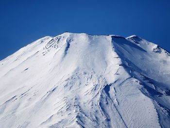 Scenic view of snowcapped mountains against clear blue sky