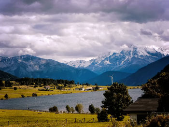 Scenic view of field, lake and mountains against sky